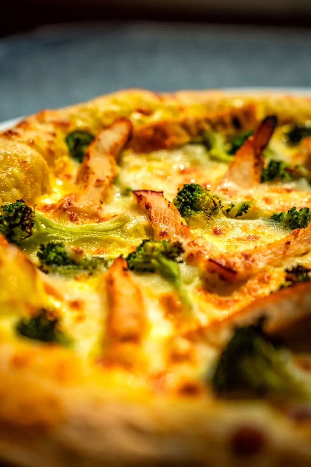 Nahaufnahme einer American Pizza mit Brokkoli und Hähnchen